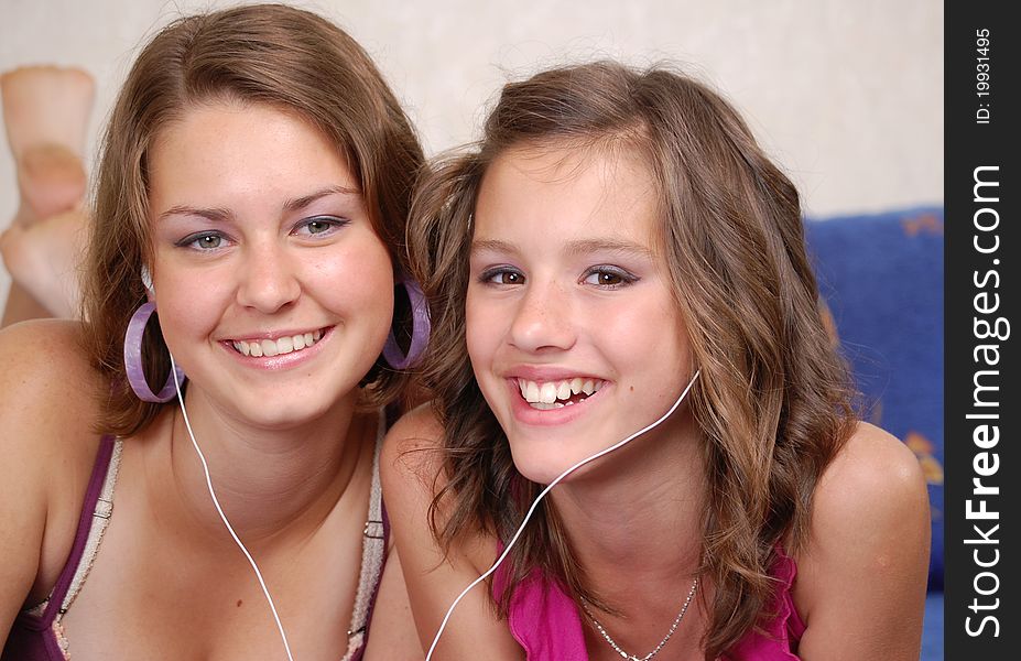 Two beautiful young teenager listening to their MP3 players. Two beautiful young teenager listening to their MP3 players