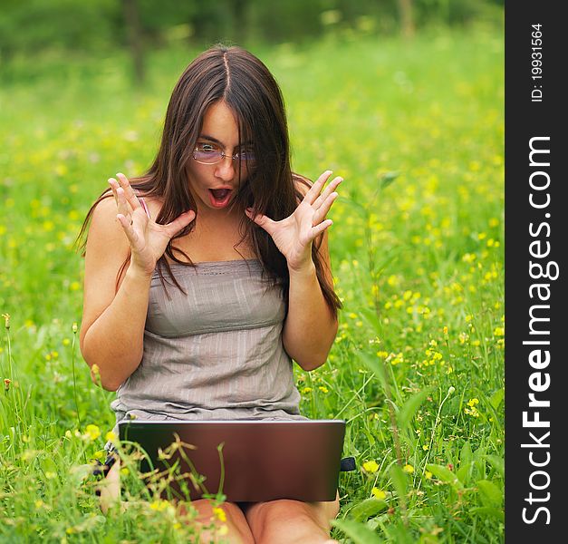 Shocked Young woman using her laptop outdoors. Shocked Young woman using her laptop outdoors.