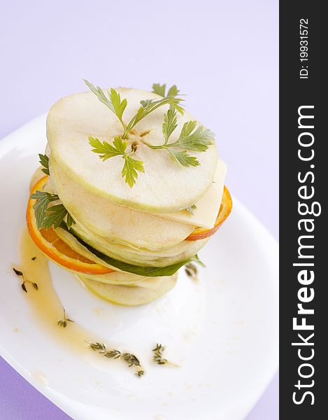 Sliced apple with herbs and orange