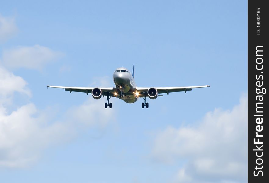 Aircraft flying against a blue sky with clouds