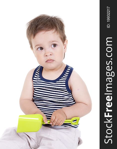 Child playing with a toy shovel on a white background. Child playing with a toy shovel on a white background