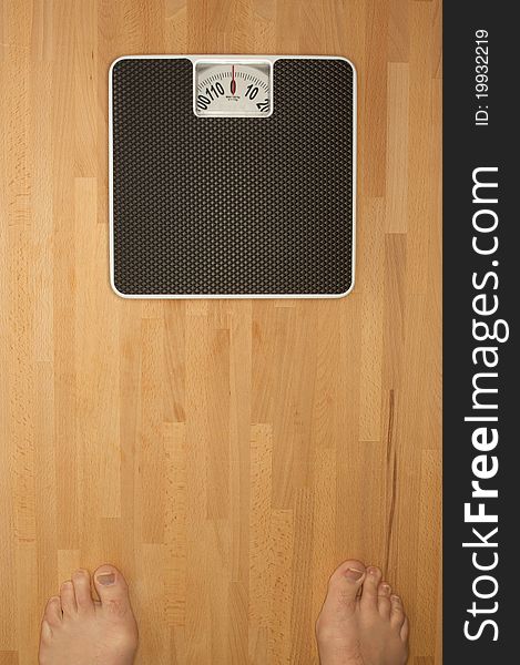 Body bathroom scales on a wooden floor