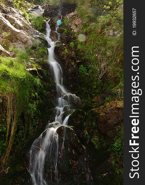 Beautiful small stream falling down rocks. Beautiful small stream falling down rocks