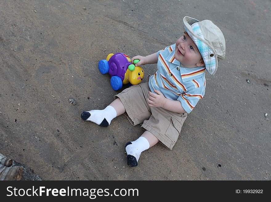 Cute little boy playing with plastic snail outdoor. Cute little boy playing with plastic snail outdoor.
