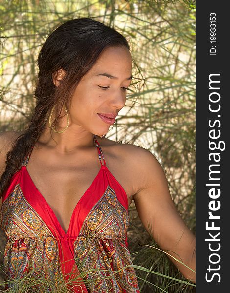 A beautiful, exotic, Hawaiian woman, framed by tall grass. Vertical image orientation. A beautiful, exotic, Hawaiian woman, framed by tall grass. Vertical image orientation.