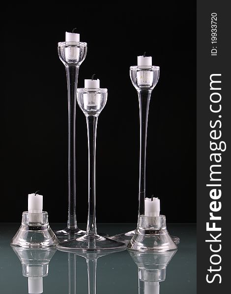 Tall glass candlesticks against black background
