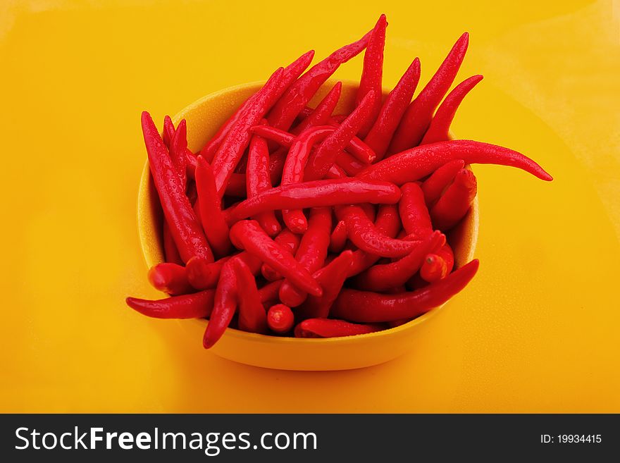 Bunch of cayenne peppers in a yellow bowl. Bunch of cayenne peppers in a yellow bowl