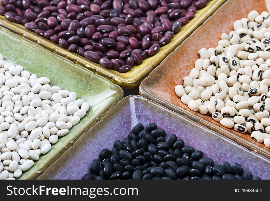 Mixed variety of dried beans in colorful square dishes. Mixed variety of dried beans in colorful square dishes