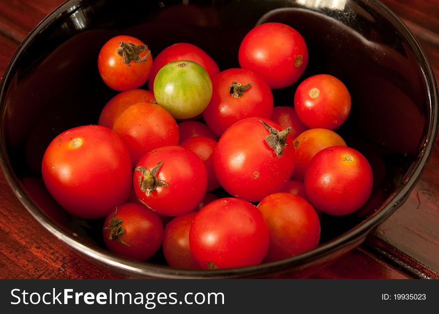 Red tomato in the black bowl
