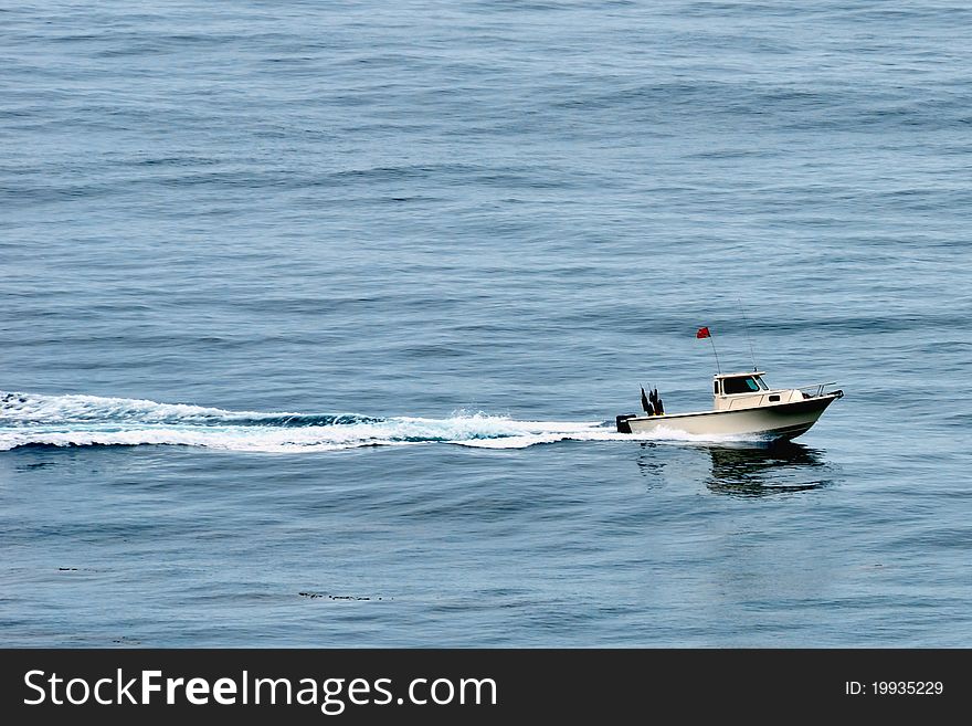 Fishing boat speeding across the ocean water.