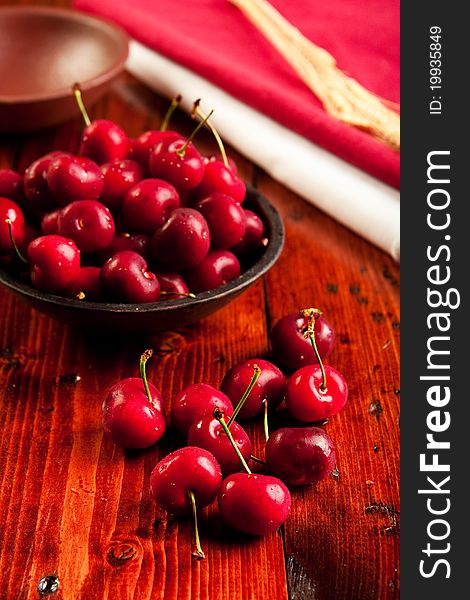 Fresh juicy cherries in a rustic bowl. Focus on foreground cherries.