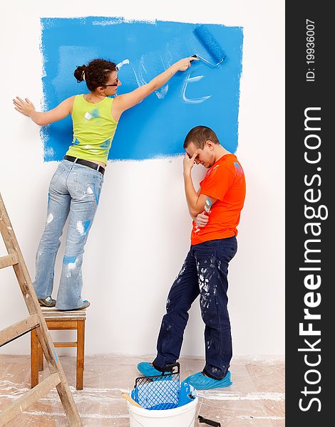 Girl repainting her love message in the wall of a renovated house. Girl repainting her love message in the wall of a renovated house