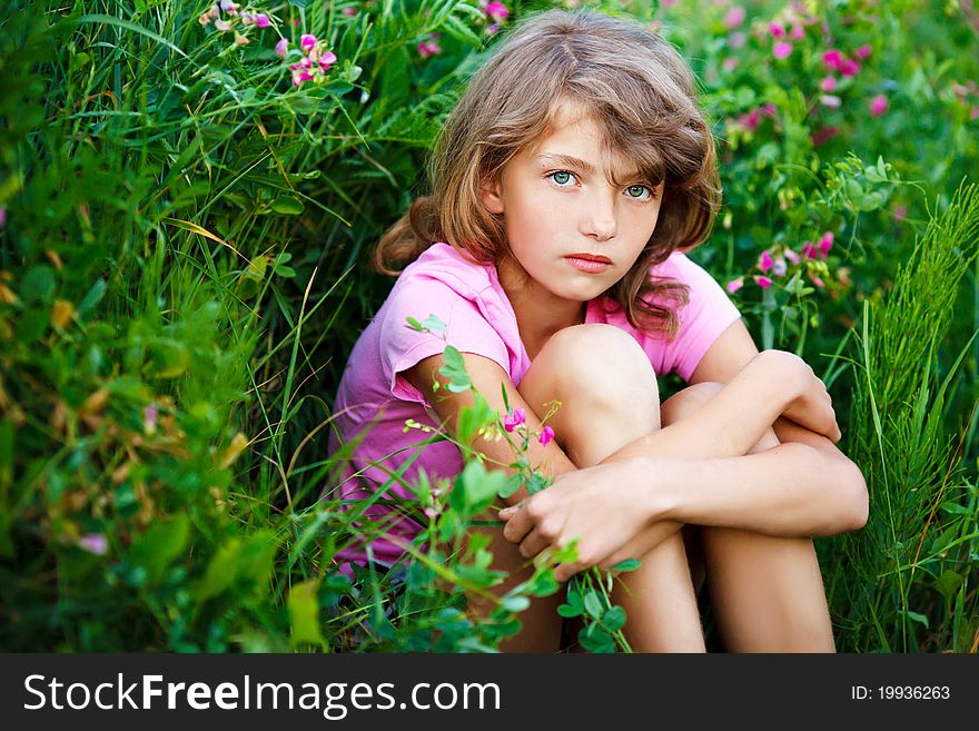 Little girl in the field with flowers