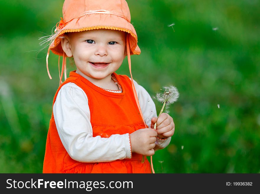 Girl blowing seeds of a dandelion flower. Girl blowing seeds of a dandelion flower