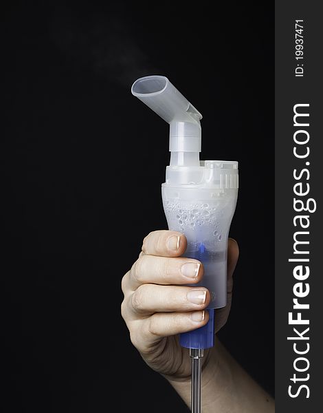 Hand holds the mouthpiece of the inhaler evaporating medicine (medical background). Hand holds the mouthpiece of the inhaler evaporating medicine (medical background)
