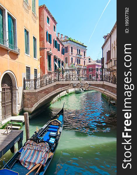 A view on canal with parked gondola in Venice,Italy. Summer in Venice. A view on canal with parked gondola in Venice,Italy. Summer in Venice.