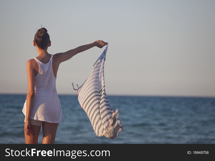 Woman holding veil or scarf at the beach. Woman holding veil or scarf at the beach