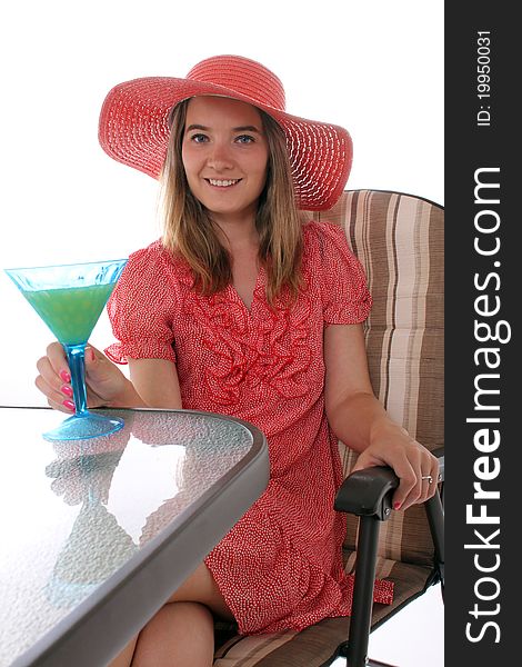 Woman sitting on a patio with a drink in hand. Woman sitting on a patio with a drink in hand