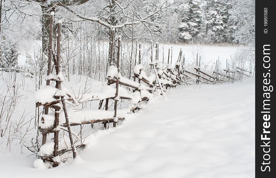 Wooden fence covered with snow. Wooden fence covered with snow.