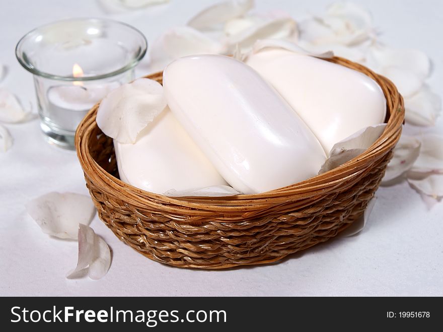 White soaps in basket with candle