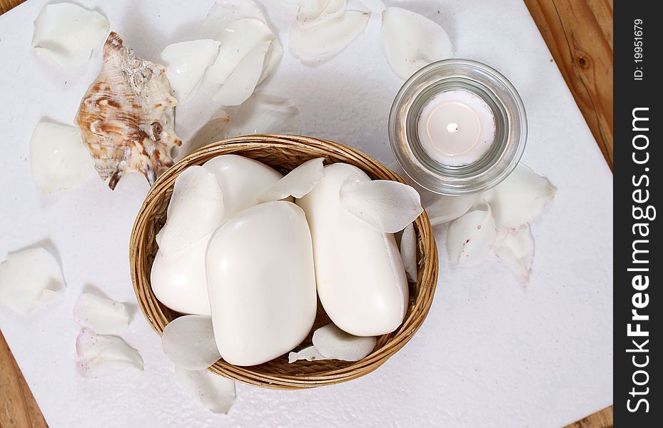 White soaps in basket with candle and seashell. White soaps in basket with candle and seashell