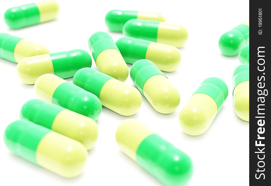 Many green-yellow pills on white background, isolated
