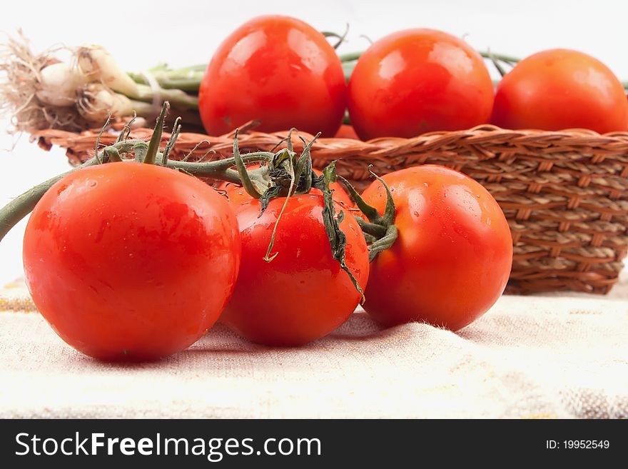 Red tomatoes in a basket on a white background