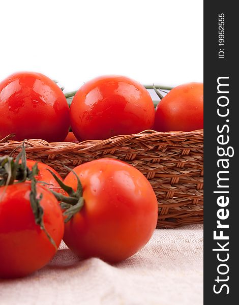 Red tomatoes in a basket on a white background