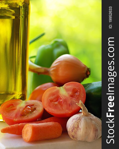 Olive oil and vegetables in green background. Olive oil and vegetables in green background.