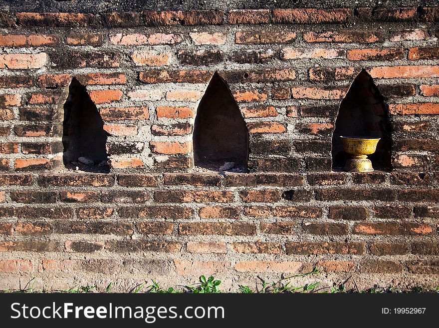 A tray used to present offerings to a monk in the Thai culture is put in a ruined wall of Wat Mahathat in Ayutthaya. A tray used to present offerings to a monk in the Thai culture is put in a ruined wall of Wat Mahathat in Ayutthaya.