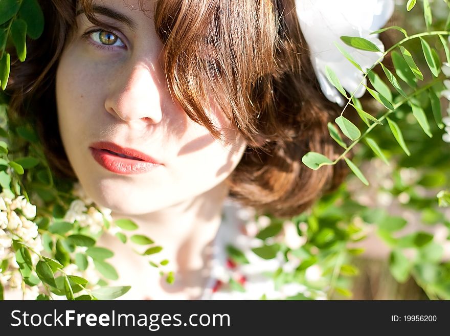 Beautiful young woman on nature with flowers