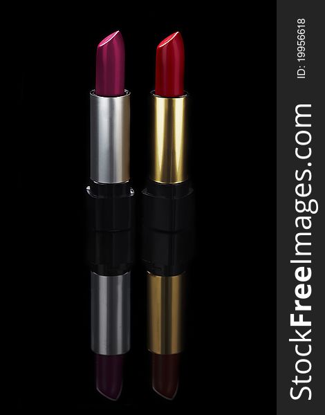 Two lipsticks on black background