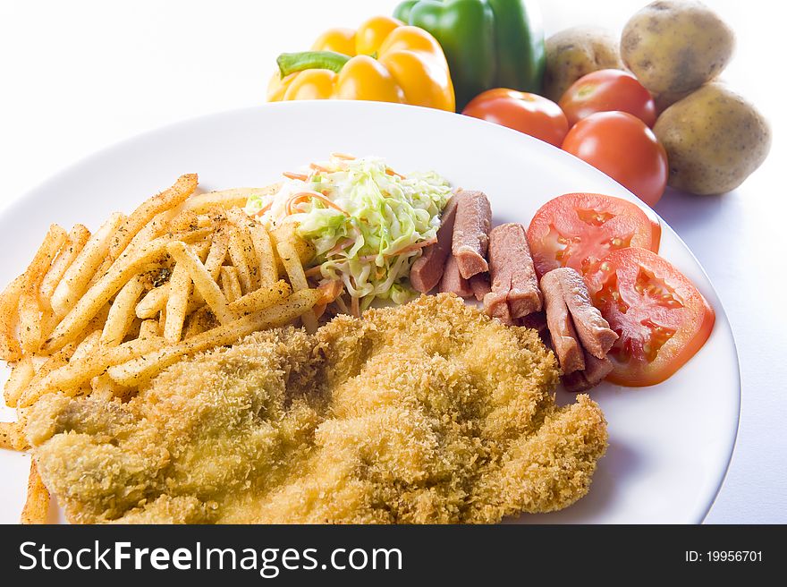 A plate of fried chicken cutlet, together with coleslaw, sausages and french fries, ready to be served for dinner or lunch!. A plate of fried chicken cutlet, together with coleslaw, sausages and french fries, ready to be served for dinner or lunch!