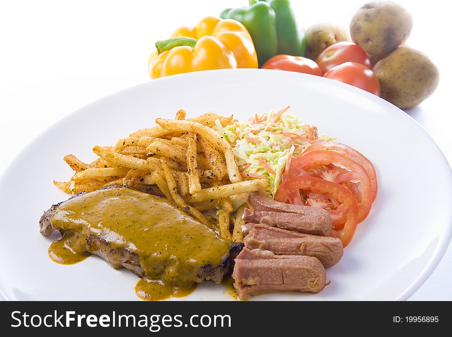 A plate of grilled steak, together with coleslaw and sausages, ready to be served for dinner or lunch!