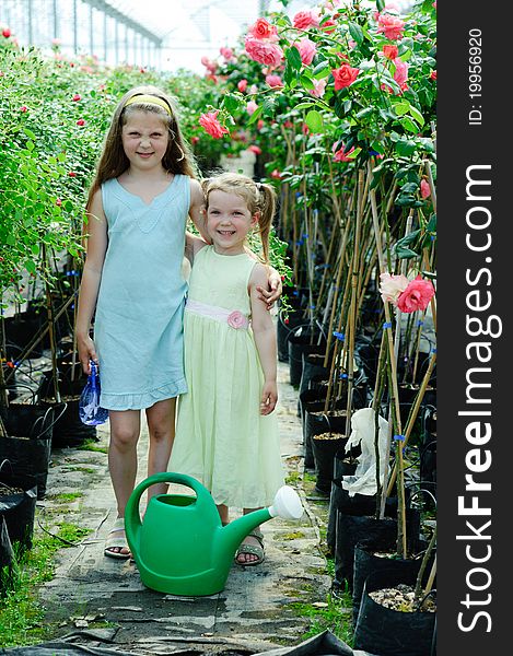 An image of two little sisters in a greenhouse
