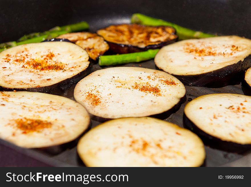 Grilled eggplants and asparagus on a griddle.