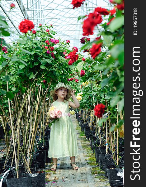 An image of a little beautiful girl in a greenhouse. An image of a little beautiful girl in a greenhouse