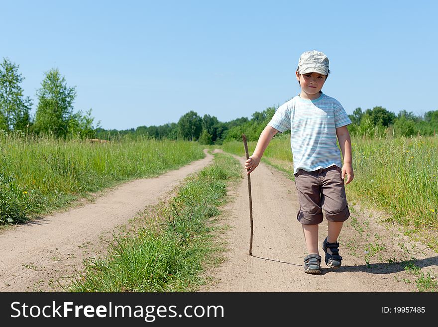 The little boy walks on rural road  in the afternoon