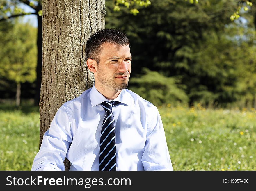 Young businessman alone in nature in summer. Young businessman alone in nature in summer