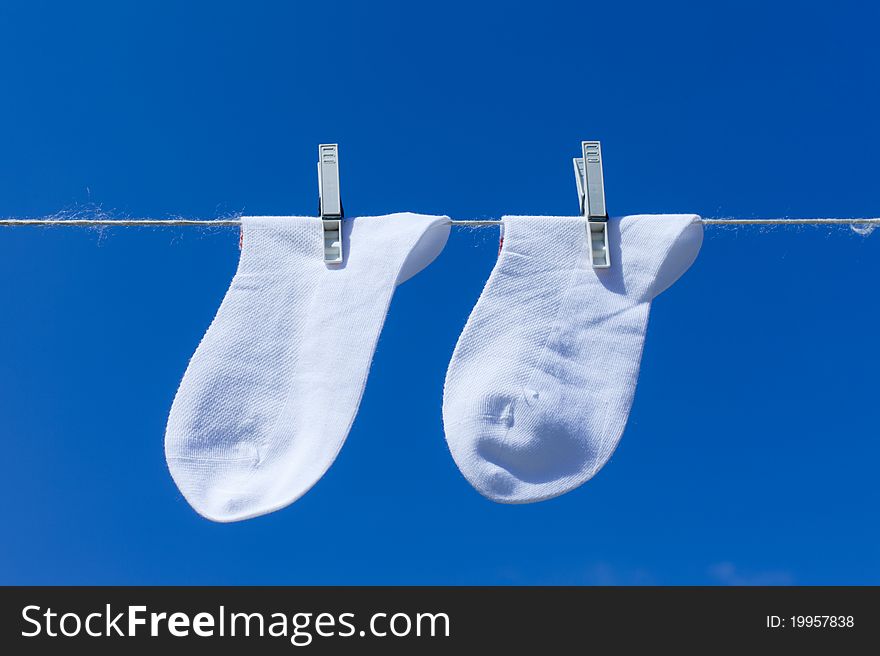 Socks hanging to dry over blue background