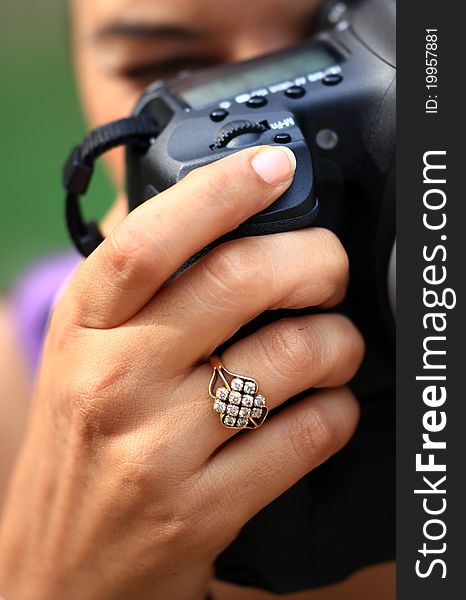 Female hand holding professional camera. Female hand holding professional camera.