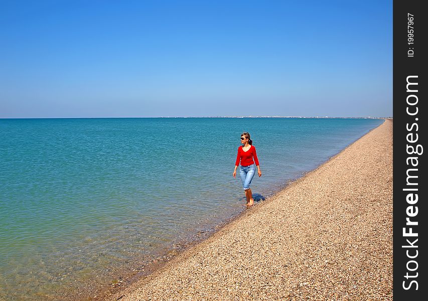 Lonely young woman walking on a coastline