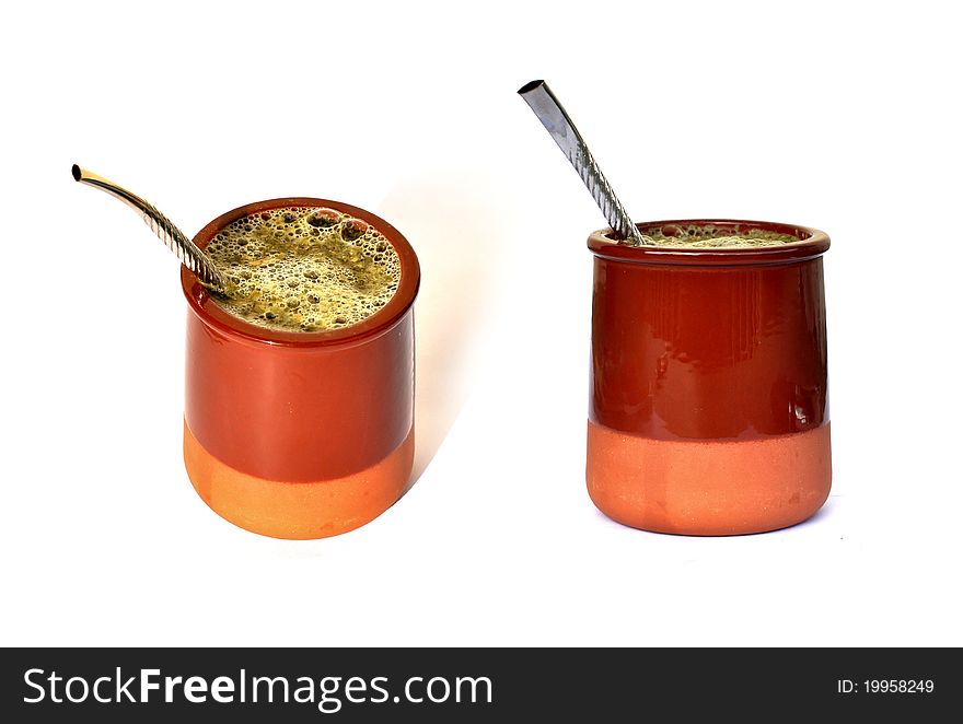 Mate herb within a ceramic cup and wter along with its stainless straw. Mate herb within a ceramic cup and wter along with its stainless straw