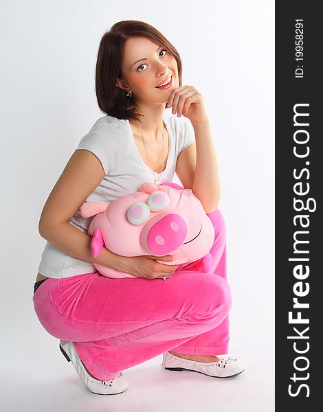 The young and beautiful girl with a plush pig. The young and beautiful girl with a plush pig