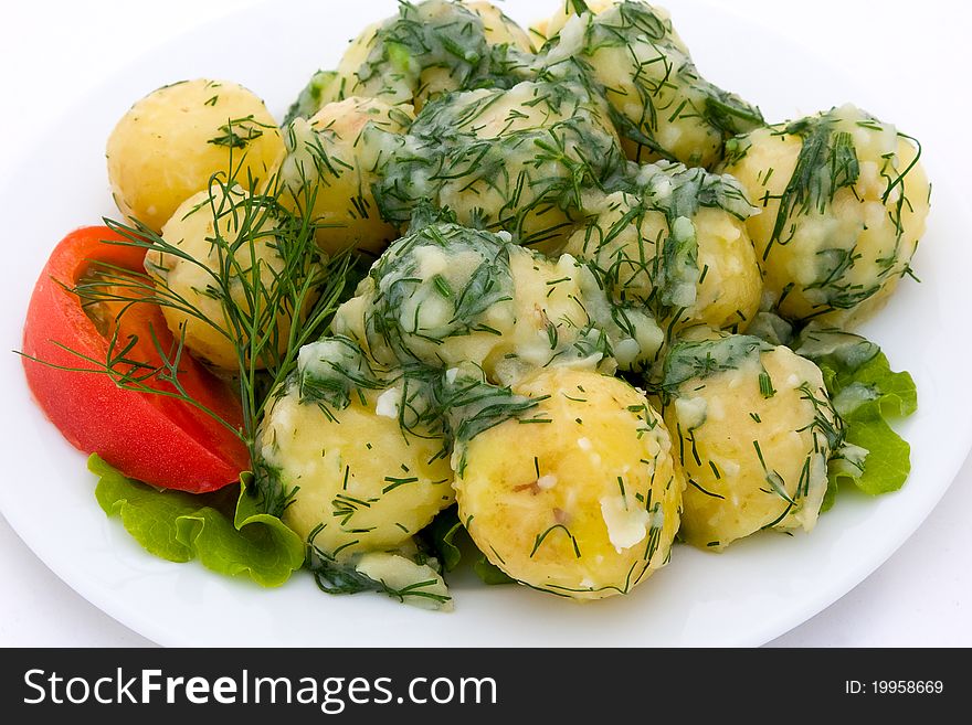 Boiled young potatoes and tomatoes with herbs on plate