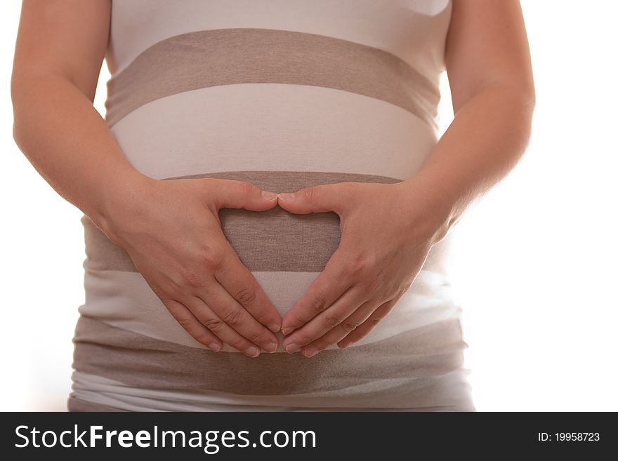 Woman's belly in 9th month of pregnancy on a white background. Hands form hart on the belly. Woman's belly in 9th month of pregnancy on a white background. Hands form hart on the belly