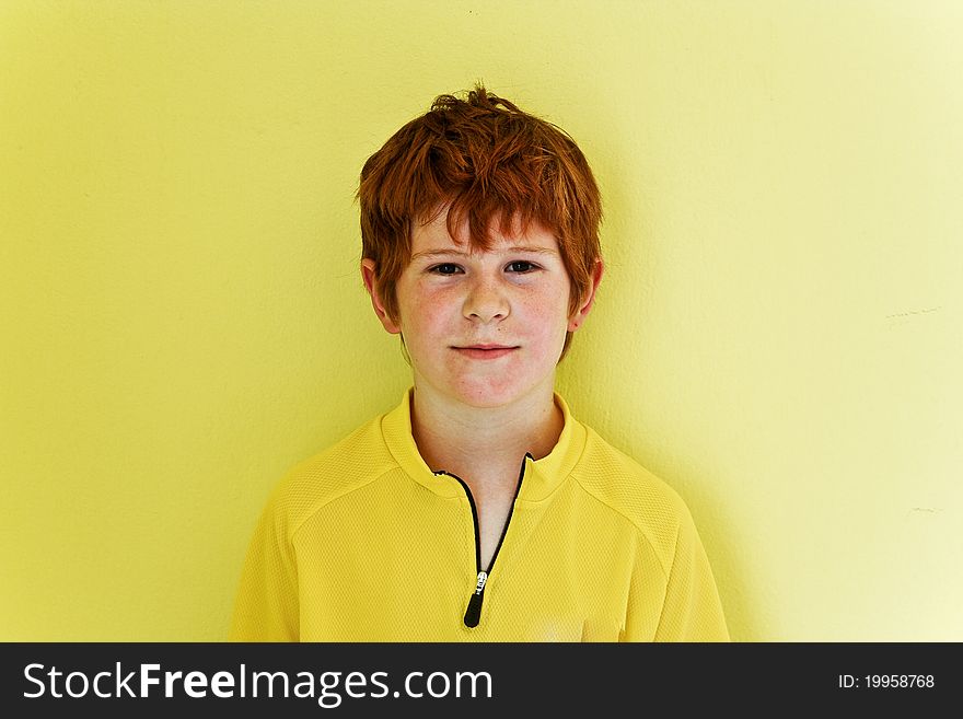 Portrait of friendly looking boy with yellow background