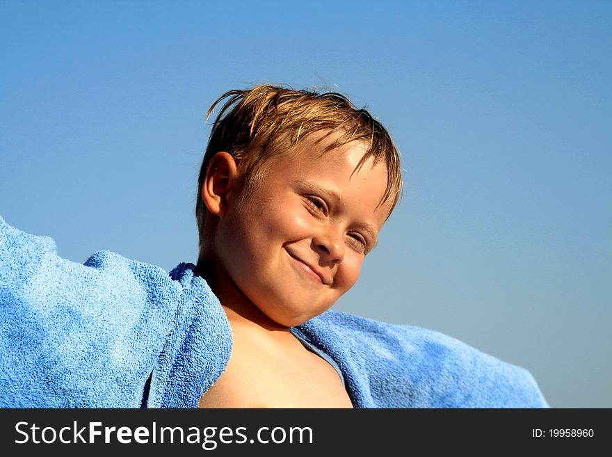 Child with towl on the beach is happy and smiles. Child with towl on the beach is happy and smiles