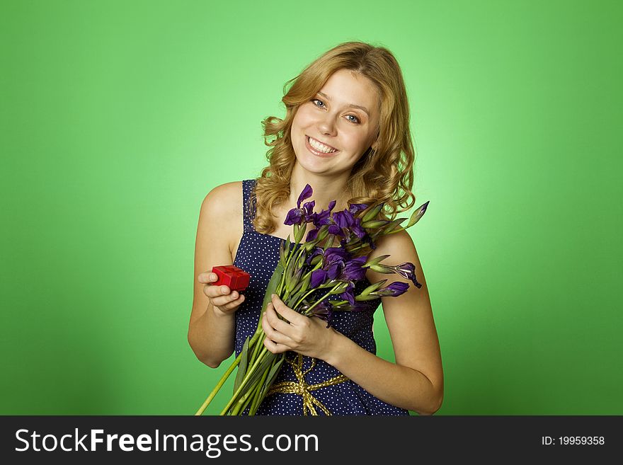 Close-up Happy young woman in one hand holding a bouquet of irises and other red gift box. Marriage proposal. Close-up Happy young woman in one hand holding a bouquet of irises and other red gift box. Marriage proposal