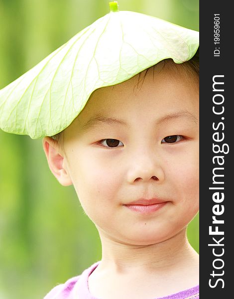 The portrait of an Asian boy with green lotus cap. The portrait of an Asian boy with green lotus cap